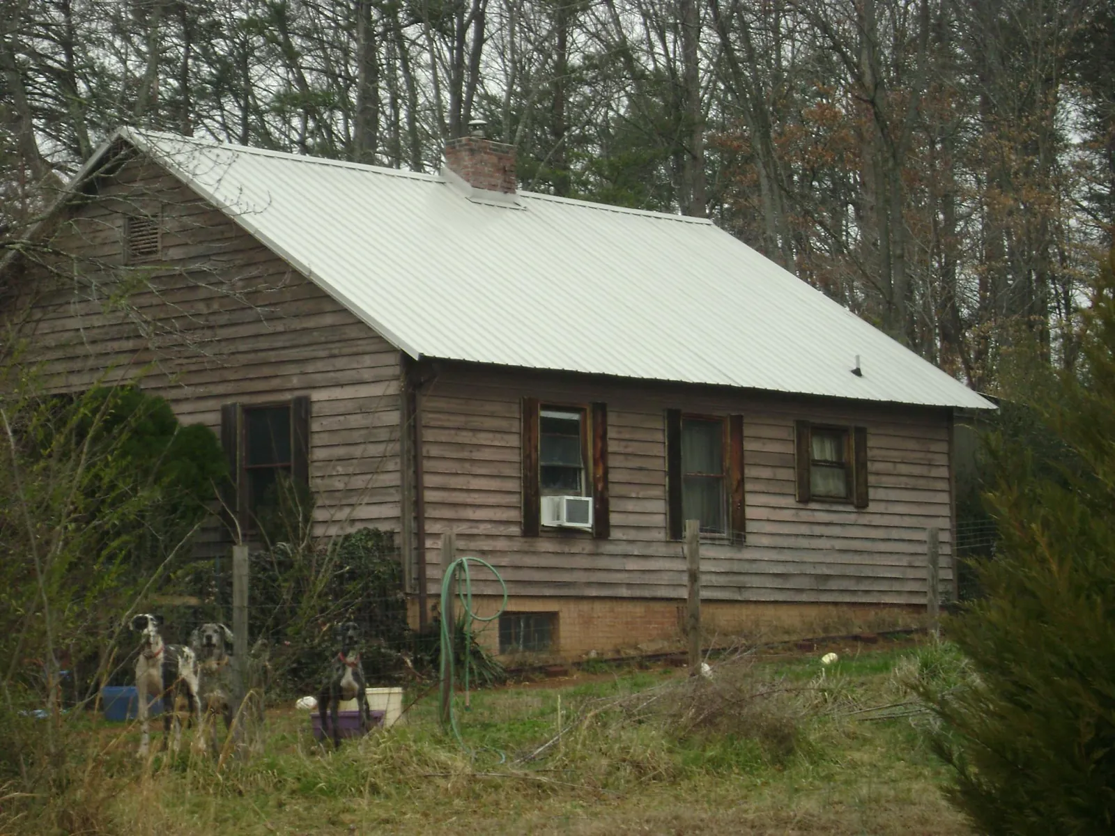 White metal roof on an old wood sided farmhouse, from a Metal Roof Installation job in Arlington